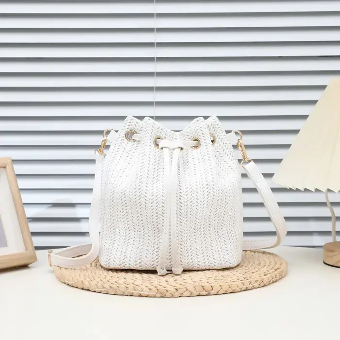 Sac seau bandoulière bohème en paille beige tressée avec cordon de serrage et sangle en cuir réglable