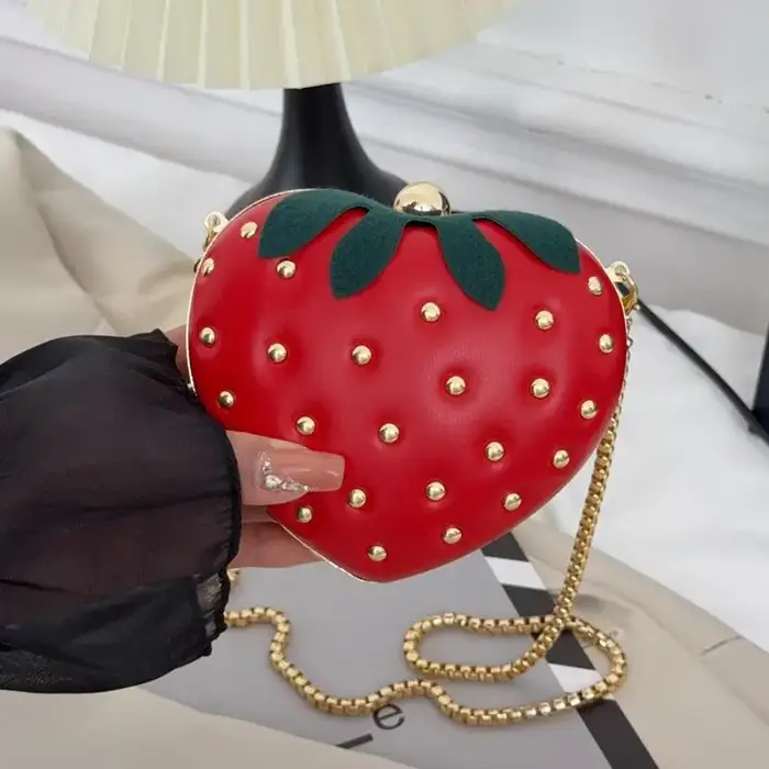 Sac bandoulière rouge en cuir motif fraise avec clous dorés et chaîne