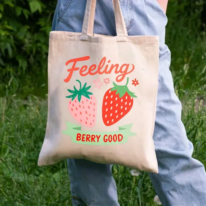Sac fourre-tout en coton imprimé fraise de couleur crème avec un design de texte "feel so good"
