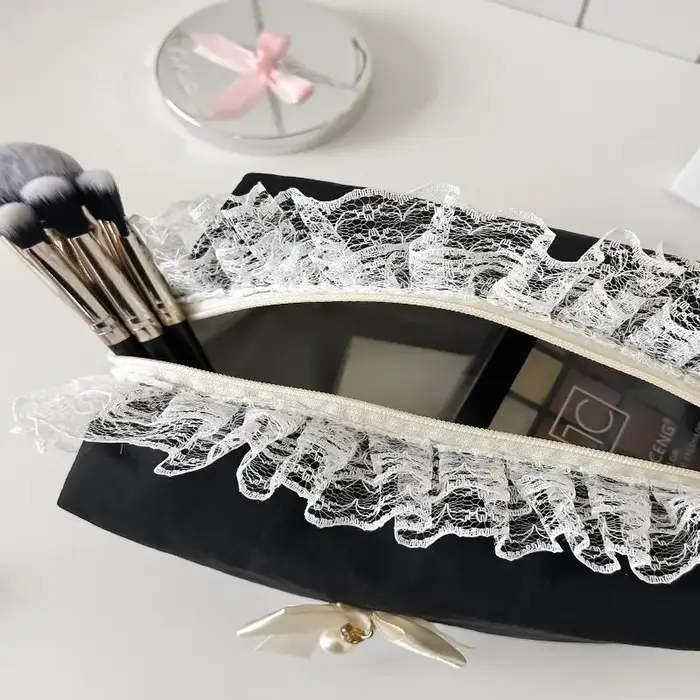 Trousse de maquillage noire en dentelle avec nœud