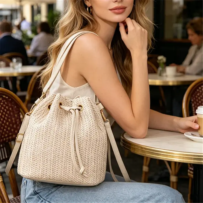 Sac seau bandoulière bohème en paille beige tressée avec cordon de serrage et sangle en cuir réglable
