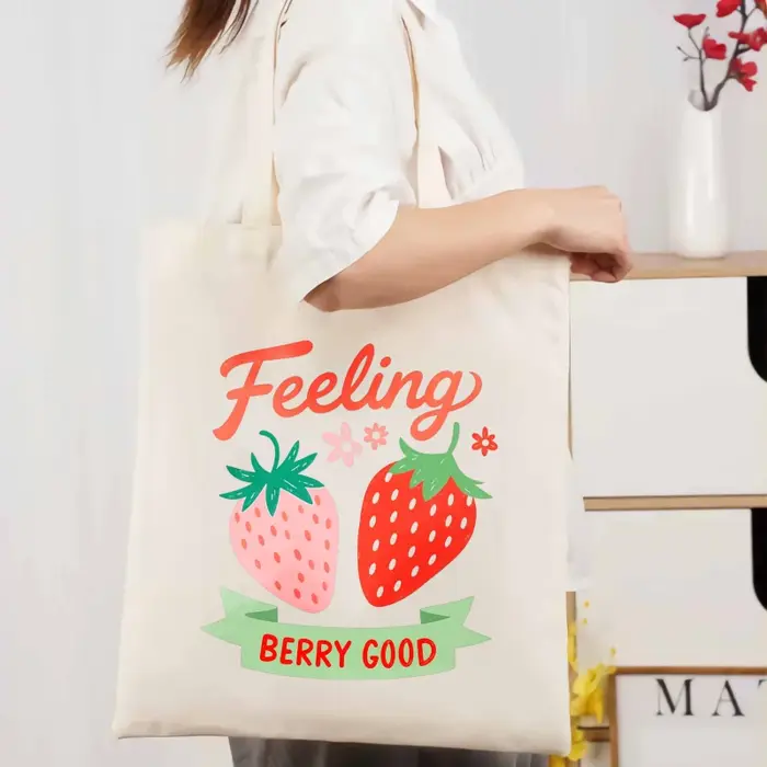 Sac fourre-tout en coton imprimé fraise de couleur crème avec un design de texte "feel so good"