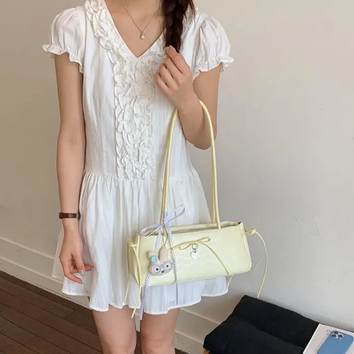 Sac à bandoulière long pour femme avec nœud à pois et breloque cœur
