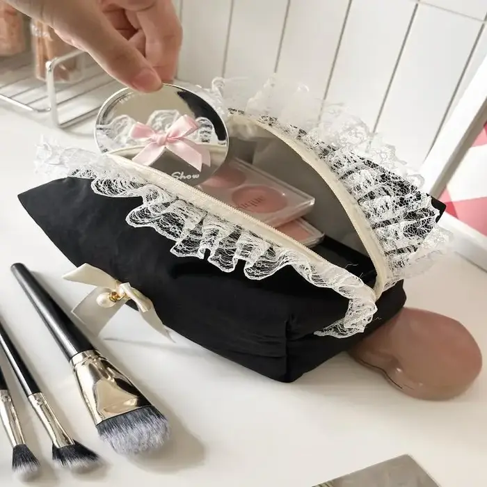 Trousse de maquillage noire en dentelle avec nœud