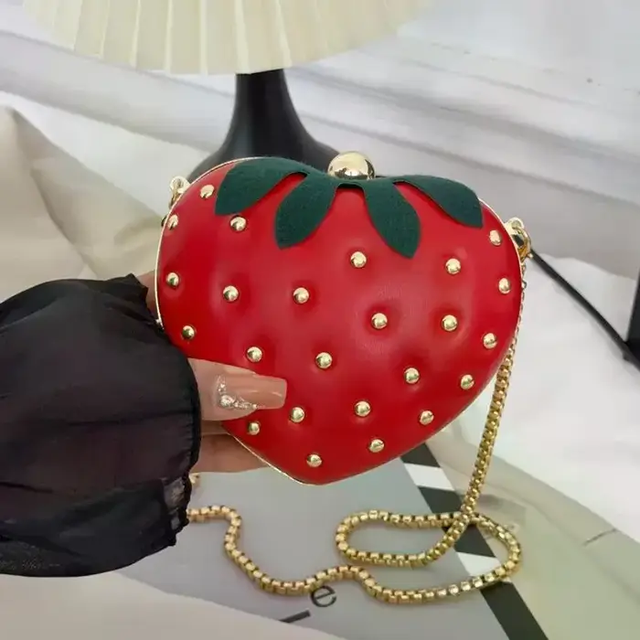 Sac bandoulière rouge en cuir motif fraise avec clous dorés et chaîne